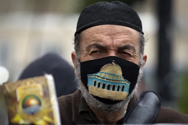 A Palestinian man wearing a face mask embroidered with an image of the Al-Aqsa Mosque takes part in a demonstration demanding protection from the coronavirus for Palestinians in Israeli jails, in the West Bank city of Ramallah, Sunday, January 31, 2021. (Photo by Majdi Mohammed/AP Photo)