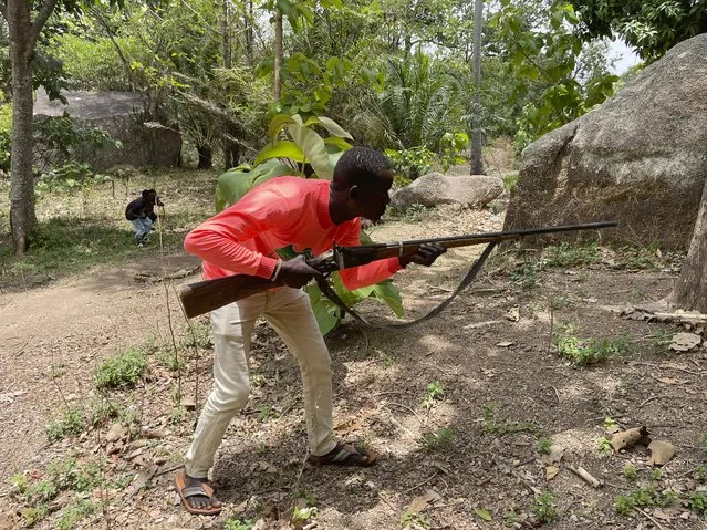 Joshua Danjuma, 36, poses with a handcrafted riffle in Kunji Village, Southern Kaduna Nigeria, Thursday, April 27, 2023. Danjuma, a hunter who lost two of his five children in a late night March 2023 gunmen attack that left 33 people dead, has joined others in protecting their homes. (Photo by Chinedu Asadu/AP Photo)