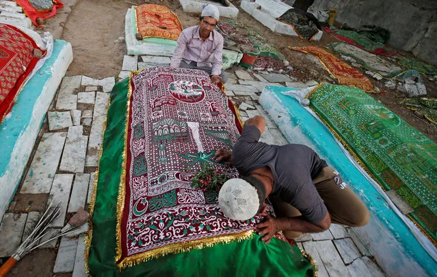 Muslim men pray at a grave at the shrine of sufi saint Shah-e-Alam during the holy month of Ramadan, in Ahmedabad, India June 13, 2018. (Photo by Amit Dave/Reuters)
