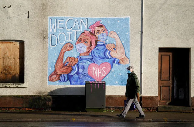 A man walks past an NHS Mural in Loughborough, Leicestershire on January 16, 2021, during England's third national lockdown to curb the spread of coronavirus. (Photo by Zac Goodwin/PA Images via Getty Images)