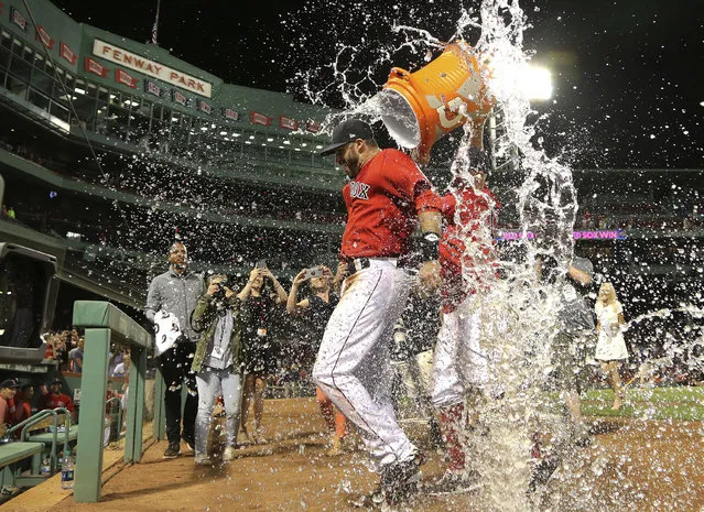 Boston Red Sox's J.D. Martinez is doused after the team's baseball game against the Seattle Mariners at Fenway Park, Friday, June 22, 2018, in Boston. Martinez singled in the go-ahead run in the Red Sox's 14-10 victory. (Photo by Elise Amendola/AP Photo)