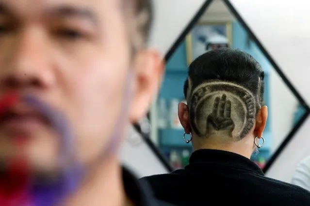 Mitree Chitinunda, a former ultra-royalist who once got a haircut of King Maha Vajiralongkorn's portrait on the back of his head with words “Long Live the King” last year, sports a new haircut with the three-fingers salute, a symbol of anti-government protest that is demanding curb for monarchy's power in Bangkok, Thailand on November 24, 2020. (Photo by Soe Zeya Tun /Reuters)