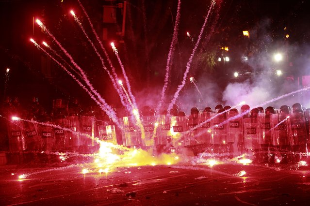 Demonstrators use firecrackers against police during a rally against the government's decision to suspend negotiations on joining the European Union for four years, outside the parliament's building in Tbilisi, Georgia, early Sunday, December 1, 2024. (Phoot by Zurab Tsertsvadze/AP Photo)