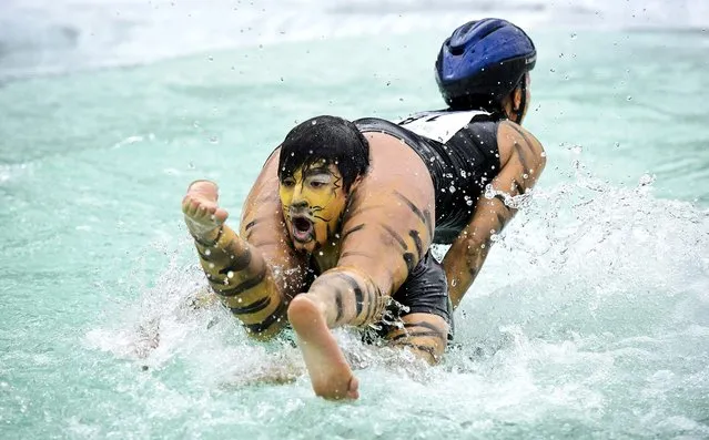 Aleksander Pihlainen and Siiri Salli compete during the Wife Carrying World Championship competition in Sonkajarvi, Finland, on July 6, 2013. (Photo by Roni Rekomaa/Lehtikuva)
