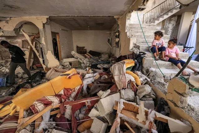 Children look on as they sit along a staircase by the rubble and broken furniture of a destroyed flat in a building in the occupied West Bank city of Jenin on July 5, 2023, after the Israeli army declared the end of a two-day military operation in the area. The Israeli military launched the raid on the Jenin refugee camp early on July 3, during which 12 Palestinians and one Israeli soldier were killed. (Photo by Ahmad Gharabli/AFP Photo)