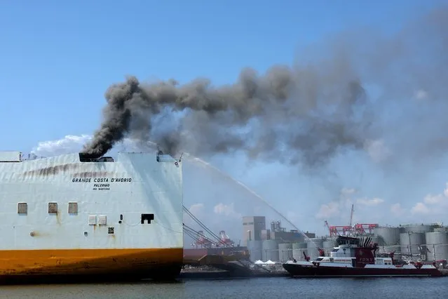A New York City Fire Department (FDNY) fire boat sprays water on a cargo ship where two New Jersey firefighters were killed after they became trapped while battling a blaze, at Port Newark, New Jersey, U.S., July 6, 2023. (Photo by Mike Segar/Reuters)