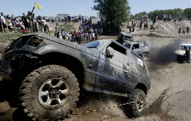 Drivers steer their all-terrain vehicles (ATV) through a mud pit during the Jeep Sprint Festival of the off-roader club “Offroad Kings” in the village of Ozernoe, Kyrgyzstan, 08 May 2022. All-terrain vehicle (ATV) enthusiasts from Kyrgyzstan and Kazakhstan took part in the races in various categories. (Photo by Igor Kovalenko/EPA/EFE)