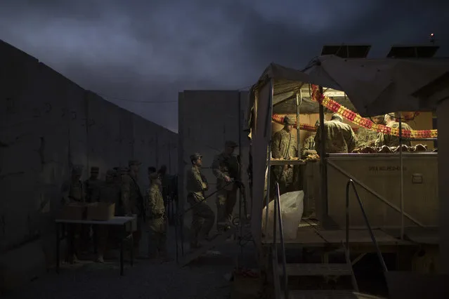 U.S. military personnel wait in line for Thanksgiving dinner at a coalition air base in Qayara south of Mosul, Iraq, Thursday, November 24, 2016. (Photo by Felipe Dana/AP Photo)