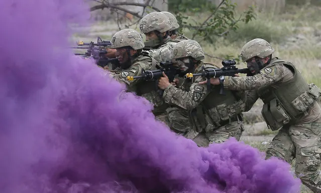 Georgian soldiers move forward behind a smoke screen as they take part in the joint multinational military exercise “Noble Partner 2018” at the military base of Vaziani, outside Tbilisi, Georgia, 09 August 2018. This time the “Noble Partner” maneuver is held on a larger-scale with the participation of more than 3,000 military servicemen of NATO member and partner countries including Georgia, the USA, UK, Germany, Estonia, France, Lithuania, Poland, Norway, Turkey, Ukraine, Azerbaijan and Armenia, according to the information of Georgia's Ministry of Defense. (Photo by Zurab Kurtsikidze/EPA/EFE)