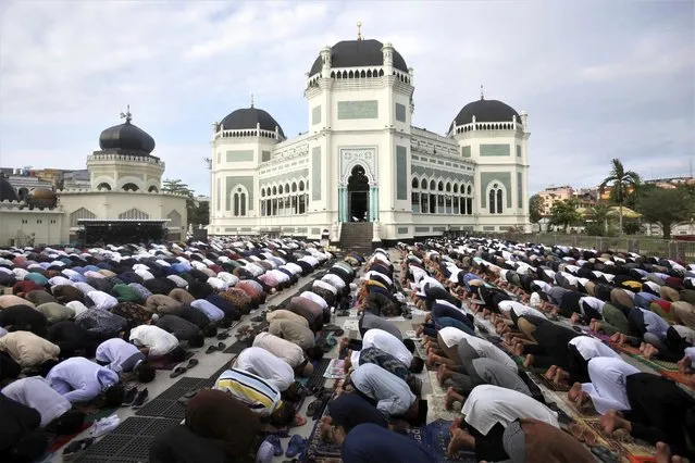 Muslims perform a morning prayer marking the Eid al-Adha holiday in front of Al Mashun Great Mosque in Medan, Indonesia, Thursday, June 29, 2023. Muslims around the world will celebrate Eid al-Adha, or the Feast of the Sacrifice, slaughtering sheep, goats, cows and camels to commemorate Prophet Abraham's readiness to sacrifice his son Ismail on God's command. (Photo by Binsar Bakkara/AP Photo)