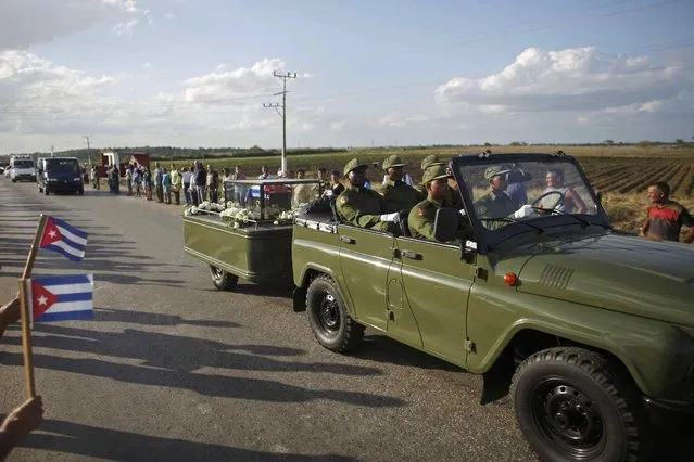 The caravan carrying the ashes of Fidel Castro pass along a street on the way to the eastern city of Santiago, in Colon, Cuba, November 30, 2016. (Photo by Alexandre Meneghini/Reuters)