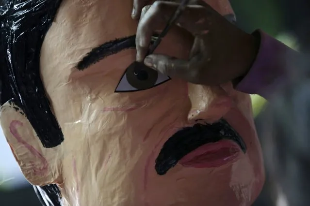 An artisan attaches eyes to a pinata depicting the drug lord Joaquin "El Chapo" Guzman at a workshop in Reynosa, in Tamaulipas state, Mexico, January 13, 2016. (Photo by Daniel Becerril/Reuters)