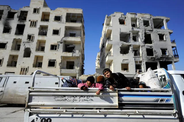 Children that came back with their families to check their homes ride a pick-up truck near damaged buildings in goverment controlled Hanono housing district in Aleppo, Syria December 4, 2016. (Photo by Omar Sanadiki/Reuters)