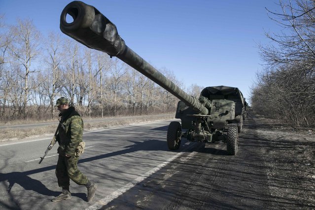 An armed man stands near a truck of the separatist self-proclaimed Donetsk People's Republic army towing a mobile artillery cannon, as they pull back from Donetsk, February 24, 2015.
 REUTERS/Baz Ratner(UKRAINE - Tags: POLITICS CIVIL UNREST CONFLICT MILITARY)