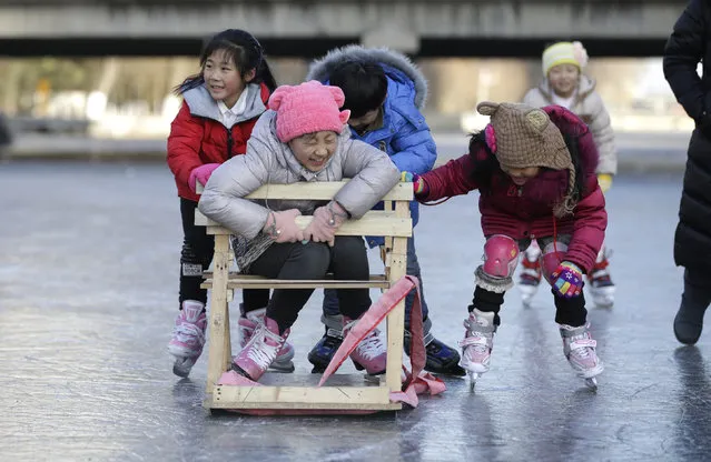 Children have fun with a specially constructed "ice-chair" on the frozen Liangmahe River in Beijing, China, January 13, 2016. (Photo by Jason Lee/Reuters)