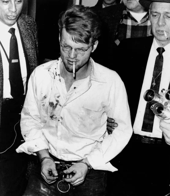 A cigarette dangles from the mouth of handcuffed killer Charles Starkweather as he is led into the Nebraska penitentiary by Sheriff Merle Karnopp, right, of Lincoln on February 1, 1958.  Bloodstains on the shirt are from minor wounds suffered during his Wyoming capture. (Photo by Don Ultang/AP Photo)