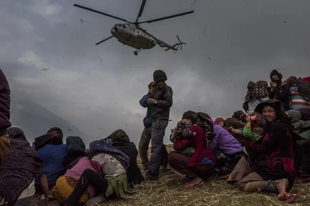 A handout image provided by the World Press Photo (WPP) organization on 18 February 2016 shows a picture by Australian photographer Daniel Berehulak for The New York Times that won Third Prize Stories in the General News Category of the 59th annual World Press Photo Contest, it was announced by the WPP Foundation in Amsterdam, The Netherlands on 18 February 2016. The picture shows Nepalese villagers looking on as they watch a helicopter picking up a medical team, dropping aid at the edge of a makeshift landing zone on May 9, 2015 in the village of Gumda, Nepal. (Photo by Daniel Berehulak/World Press Photo Contest/EPA)