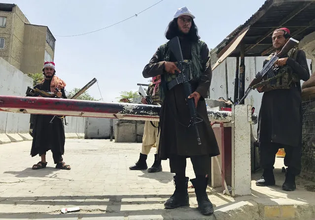 Taliban fighters stand guard at a checkpoint near the US embassy that was previously manned by American troops, in Kabul, Afghanistan, Tuesday, August 17, 2021. The Taliban declared an “amnesty” across Afghanistan and urged women to join their government Tuesday, seeking to convince a wary population that they have changed a day after deadly chaos gripped the main airport as desperate crowds tried to flee the country. (Photo by AP Photo/Stringer)