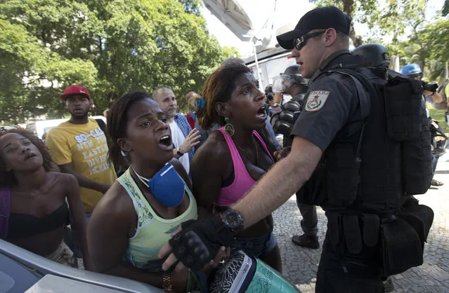 Women are held back by police after their friend was detained during their eviction from a building they invaded about a week ago in the Flamengo neighborhood of Rio de Janeiro, Brazil, Tuesday, April 14, 2015. (Photo by Silvia Izquierdo/AP Photo)