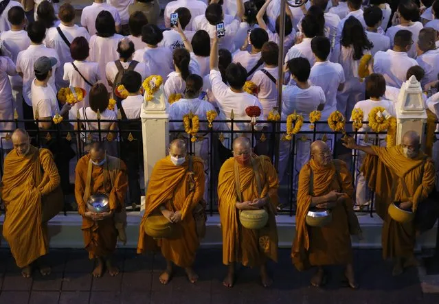 Thai Buddhist monks line up for a morning alms, while the believer of the Lord Brahma are worship mark the religious ceremony for to mark the 67th establishment anniversary of the Erawan shrine in Bangkok, Thailand, 09 November 2023. The ceremony is held every year in the early morning of 09 November to worship the Lord Brahma statue to commemorate it being enshrined on 09 November 1956. (Photo by Narong Sangnak/EPA)