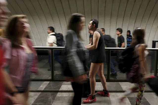 A passenger stands without pants inside the subway as people walk pass during the “No Pants Subway Ride” in Mexico City, Mexico, February 21, 2016. (Photo by Carlos Jasso/Reuters)