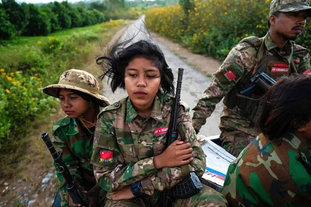 This photo taken on December 10, 2023 shows female members of the Mandalay People's Defense Forces (MDY-PDF) heading to the frontline amid clashes with the Myanmar military in northern Shan State. In the hills of northern Myanmar young women fly combat drones, treat wounded comrades and patrol the frontlines, new roles in the battle to overthrow the military junta. (Photo by AFP Photo/Stringer)