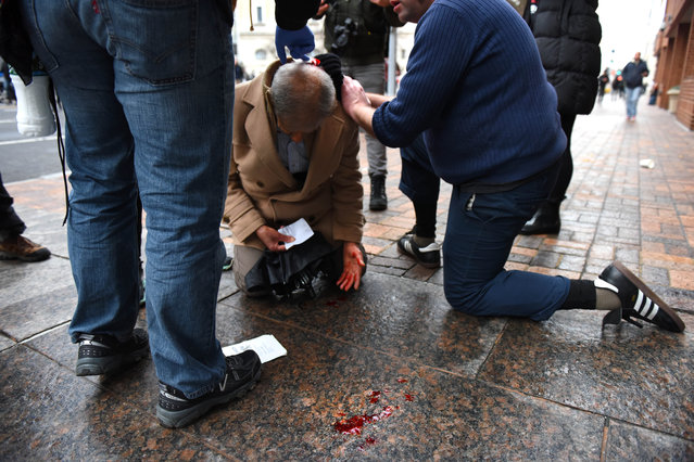 A man is tended to after being injured by a flash bang device in Washington DC on January 20, 2017. Metro Police responded to a vandalizing group of protesters with pepper spray to disperse the protesters. (Photo by Michael Robinson Chavez/The Washington Post)