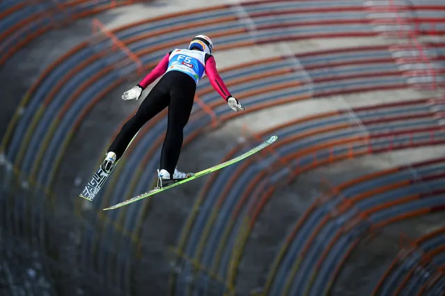 A forerunner soars through the air as he flies over empty stands during training for the Ski Jumping HS130, at the Nordic ski World Championships in Innsbruck, Austria, Wednesday, February 20, 2019. (Photo by Michael Dalder/Reuters)