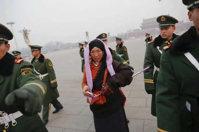 Paramilitary policemen tell people to leave Tiananmen Square shortly after a flag-raising ceremony as the area near the Great Hall of the People is prepared for upcoming annual sessions of the National People's Congress (NPC) and Chinese People's Political Consultative Conference (CPPCC) in Beijing March 3, 2016. (Photo by Damir Sagolj/Reuters)