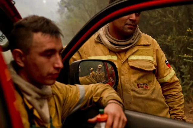 In this Friday, January 27, 2017 photo, firefighters takes a break from digging trenches, as wildfires threaten Florida, a community of Concepcion, Chile. More than 20,000 people, including firefighters and experts from more than a dozen countries, have battled wildfires that President Michelle Bachelet has called the worst forest disaster in Chile's history. (Photo by Esteban Felix/AP Photo)