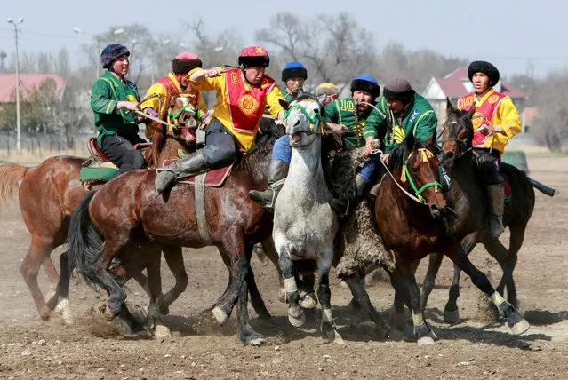 Horsemen take part in a Kok-boru, or goat dragging competition as part of Navruz celebrations, an ancient holiday marking the spring equinox, in Bishkek, Kyrgyzstan March 18, 2019. Mounted players compete for points by throwing a stuffed sheepskin into a well. Games are dedicated to the celebration of Nowruz, “The New Year” in Farsi, is an ancient festival marking the first day of spring in Central Asia on March 21. (Photo by Vladimir Pirogov/Reuters)