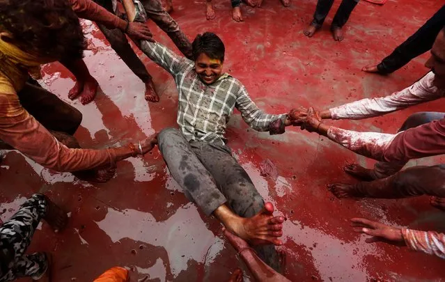 Hindu devotees take part in the religious festival of Holi inside a temple in Nandgaon village, in the state of Uttar Pradesh, India, March 16, 2019. (Photo by Adnan Abidi/Reuters)