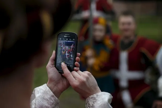 A woman takes picture with of fighter during the Medieval Combat World Championship at Malbork Castle, northern Poland, April 30, 2015. (Photo by Kacper Pempel/Reuters)