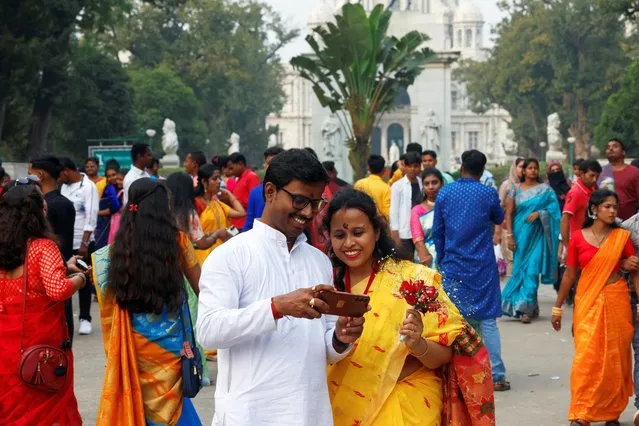 A couple dressed in traditional Bengali attire share a moment outside the Victoria Memorial monument on the occasions of the Hindu festival of Basant Panchami and Valentine's Day, in Kolkata, India, on February 14, 2024. (Photo by Sahiba Chawdhary/Reuters)