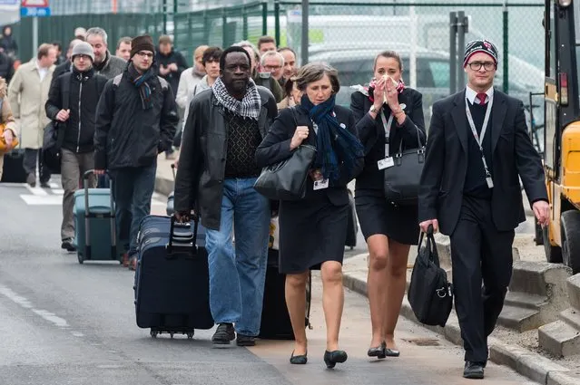 People react as they walk away from Brussels airport after explosions rocked the facility in Brussels, Belgium Tuesday March 22, 2016. Explosions rocked the Brussels airport and the subway system Tuesday, just days after the main suspect in the November Paris attacks was arrested in the city, police said. (Photo by Geert Vanden Wijngaert/AP Photo)
