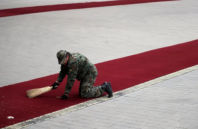 A military member sweeps a red carpet before Pope Francis arrival in Sofia, Bulgaria on May 5, 2019. (Photo by Alkis Konstantinidis/Reuters)