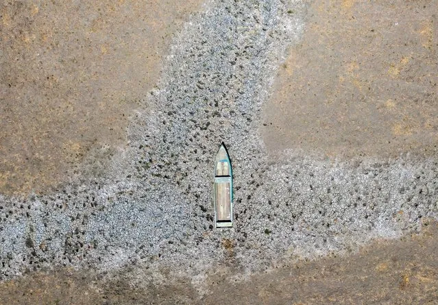 Aerial view of a small boat on dried-up land where there used to be water in Lake Cuitzeo at the Mariano Escobedo community, Michoacan State, Mexico, taken on March 3, 2024. Fishermen from the Mariano Escobedo community suffer from the problem of the lake drying up. Lake Cuitzeo is the second-largest lake in Mexico and has now lost almost 75% of its capacity, according to researchers from the Michoacan University of San Nicolas de Hidalgo. The Cuitzeo Lake basin begins in Morelia and ends in the state of Guanajuato. (Photo by Enrique Castro/AFP Photo)