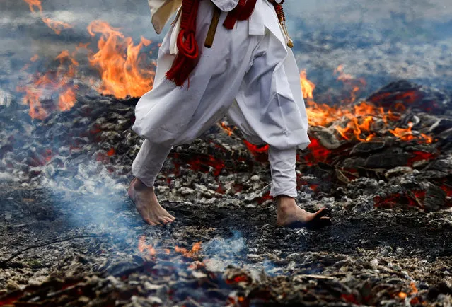 A Buddhist monk walks over smouldering coals barefoot at the fire-walking festival, called Hiwatari Matsuri in Japanese, at Mt.Takao in Tokyo, Japan, on March 10, 2024. Over 1,000 worshipers walk barefoot with Buddhist monks over coals at the annual festival, praying for their safety and peace in the world, according to the organiser Takao-san Yakuo-in Buddhist temple. (Photo by Issei Kato/Reuters)