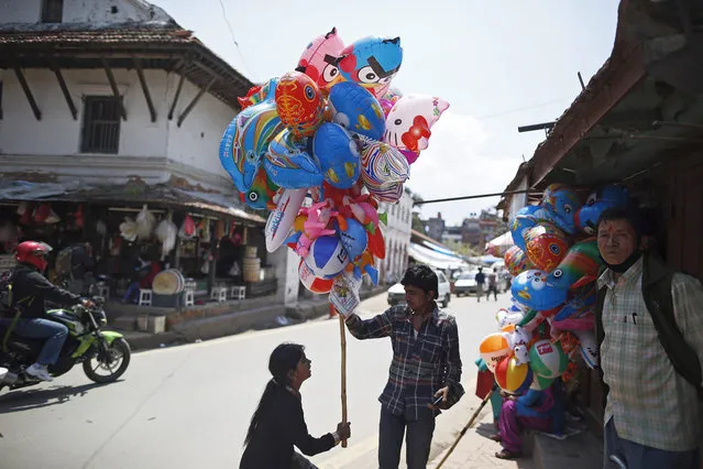 Nepalese street vendors wait for customers at a market in Patan, Nepal, 17 May 2015. (Photo by Mast Irham/EPA)