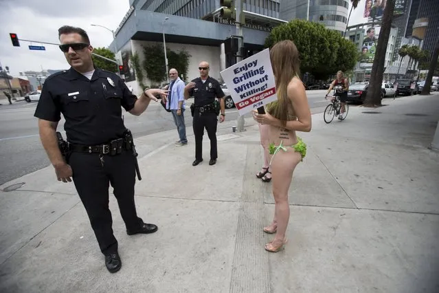 Police officers talk to activists from People for the Ethical Treatment of Animals (PETA) promoting a vegan diet in Los Angeles, California May 21, 2015. (Photo by Mario Anzuoni/Reuters)