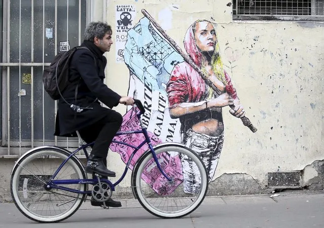 A man cycles past graffiti on a wall depicting a woman holding a French flag during a demonstration against a French labour law proposal in Paris, France, April 9, 2016. (Photo by Charles Platiau/Reuters)