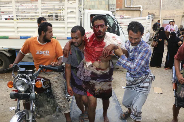 People carry a man who was injured during clashes between tribal fighters loyal to the exiled President Abed Rabbo Mansour Hadi and Shiite rebels known as Houthis in the western city of Taiz, Yemen, Sunday, May 24, 2015. Security officials said fighting is raging on in Yemen, with airstrikes by the Saudi-led coalition hitting Shiite rebel targets in multiple cities, including the capital, Sanaa, while street battles in the city of Taiz have killed several civilians. (Photo by Abdulnasser Alseddik/AP Photo)