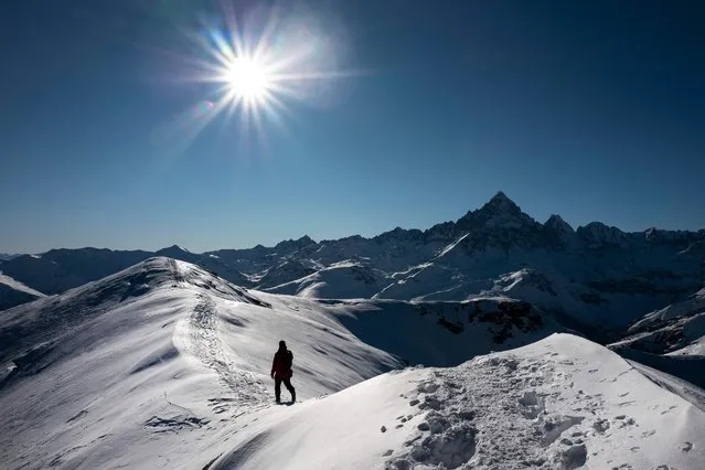 A hiker walks on Riscas Peak at the Monviso Biosphere Area in Ostana, near the French border, northwestern Italy, Alps Region, on December 6, 2021. (Photo by Marco Bertorello/AFP Photo)
