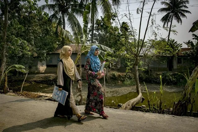 Rani (blue scarf) walks with a friend to catch a rickshaw to take a school exam March 6, 2017 in Khulna division, Bangladesh. (Photo by Allison Joyce/Getty Images)