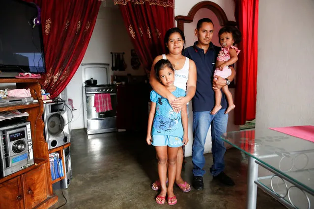 Lender Perez (2nd R), his wife Isamar Ramirez (2nd L) and their children Lismar (L) and Lucia, pose for a picture  at their home in Caracas, Venezuela April 14, 2016. “We have about 15 days eating bread with cheese or arepa with cheese. We are eating worse than before, because we can't find food and those we can find we can't afford”. (Photo by Carlos Garcia Rawlins/Reuters)