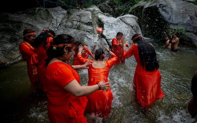 Nepalese Hindu pilgrims, also known as Bolboms, engage in the worship of Shiva, the god of creation and destruction, in Sundarijal, 15 km from Kathmandu, Nepal, 29 July 2019. Thousands of Bolbom devotees form across the country travel barefoot to the northern holy city Sundarijal, 16 km from the capital, where they collect water, claimed to be holy. The water is stored in two pots on colorful wooden sticks, which are not allowed to be placed on the ground until end of the procession. Bolboms believe that all their sins and mistakes committed in life will be forgiven by taking part in this ceremony. (Photo by Narendra Shrestha/EPA/EFE/Rex Features/Shutterstock)