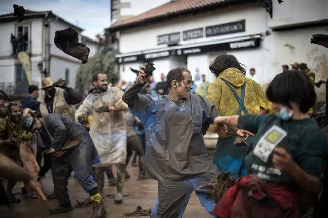 Reveller throw rag of muds as they take part in the “Farrapada” during the traditional carnival of Laza, northwestern Spain, on February 28, 2022. (Photo by Miguel Riopa/AFP Photo)