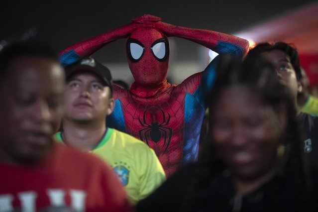 A soccer fan dressed as Spiderman watches Brazil play Uruguay in a Copa America quarterfinal match on a screen set up for fans on Copacabana Beach in Rio de Janeiro, July 7, 2024. Brazil lost in a penalty shootout. (Photo by Bruna Prado/AP Photo)