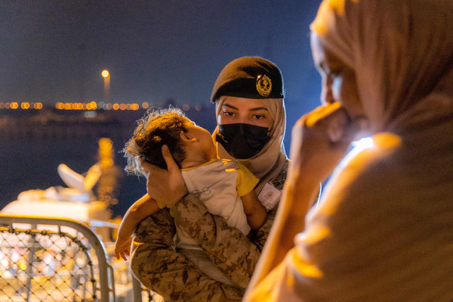 This handout picture provided by the Saudi Media Ministry on April 24, 2023 shows a member of the Saudi Navy Forces carrying an evacuee baby upon arrival at King Faisal navy base in Jeddah, following a rescue operation from Sudan. Elderly women in wheelchairs and babies asleep in their parents' arms were among nearly 200 people from 14 countries who disembarked from a naval frigate in the coastal city of Jeddah on Monday night after daring – and draining – journeys to safety. (Photo by SPA/AFP Photo)