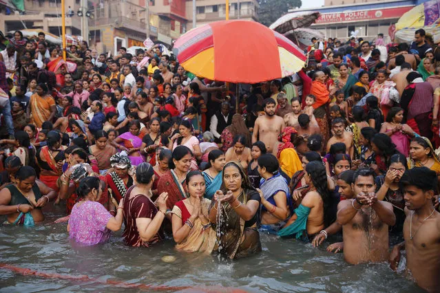 Hindu devotees crowd the bank of the River Ganges, holy to Hindus, to take dips and offer prayers during Karthik Purnima festival in Varanasi, India, Tuesday, November 12, 2019. The festival which falls on the full moon day of the Indian calendar month of Karthik, is considered auspicious. (Photo by Rajesh Kumar Singh/AP Photo)